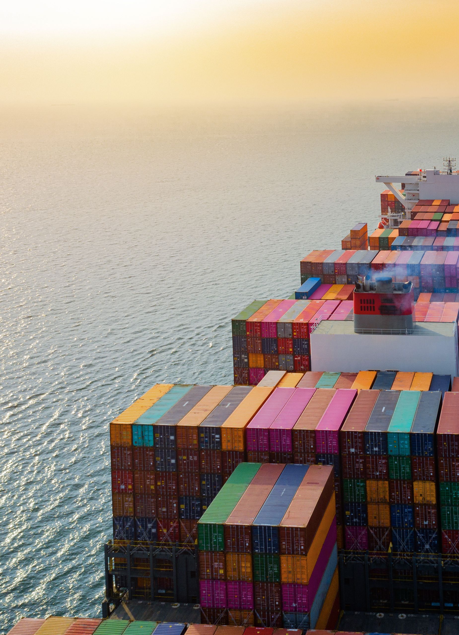top aerial view of the large volume of TEU containers on ship sailing in the sea carriage the shipment from loading port to destination, heading to the destination of success light